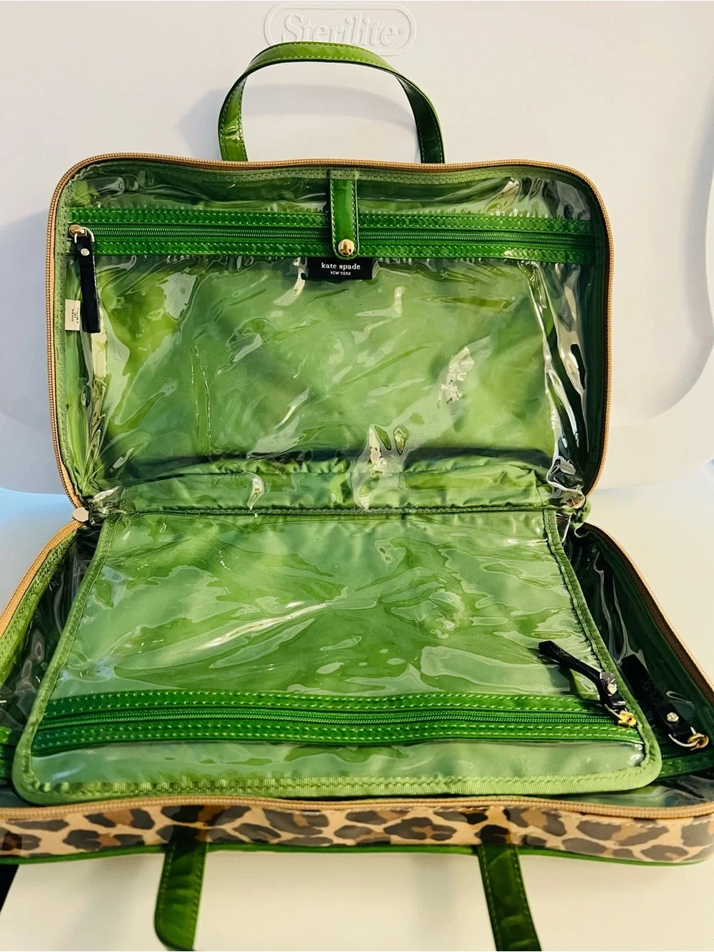 Brand new. Large Kate Spade cosmetic bag. Leopard print with green lining/trim.